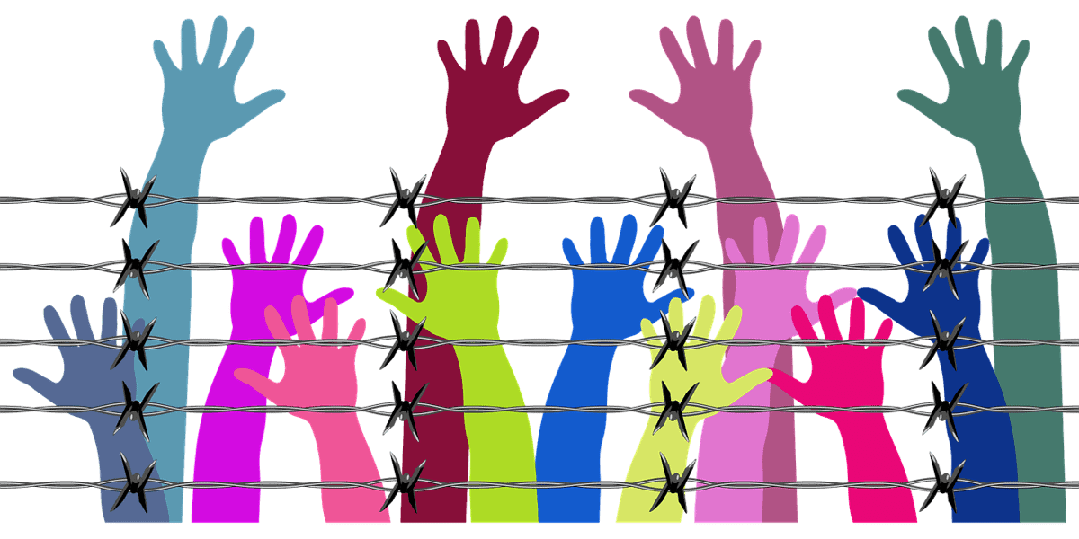 Image of hands reaching over barbed wire jail. Public utility app Appolition aims to raise funds for bail.