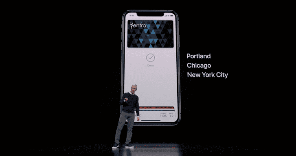 Tim Cook on stage in front of a slide displaying an iPhone with a transit card in the Wallet app