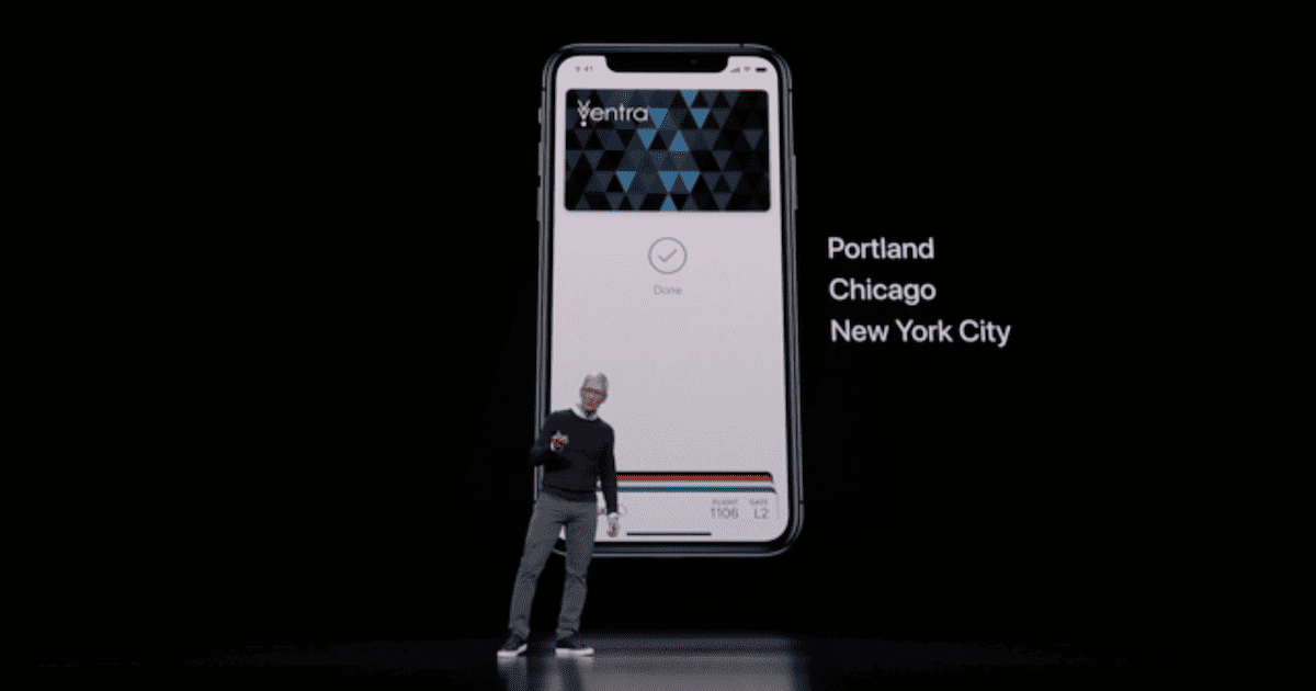 Tim Cook on stage in front of a slide displaying an iPhone with a transit card in the Wallet app