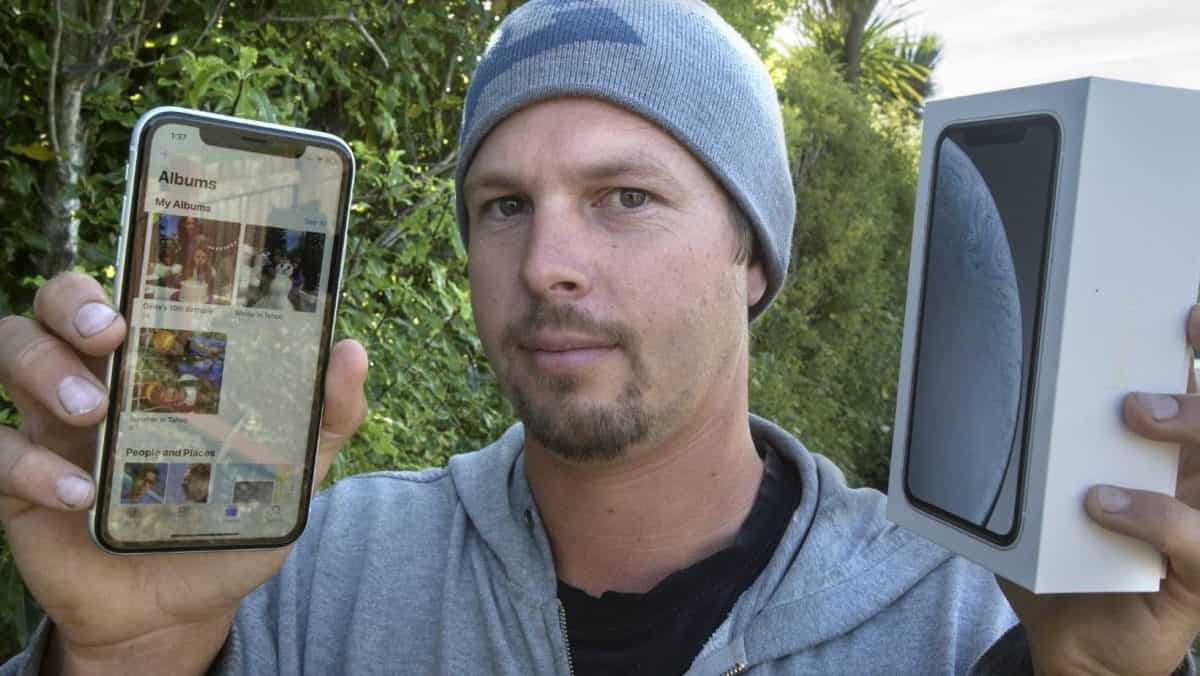 Image of man holding previously used iphone