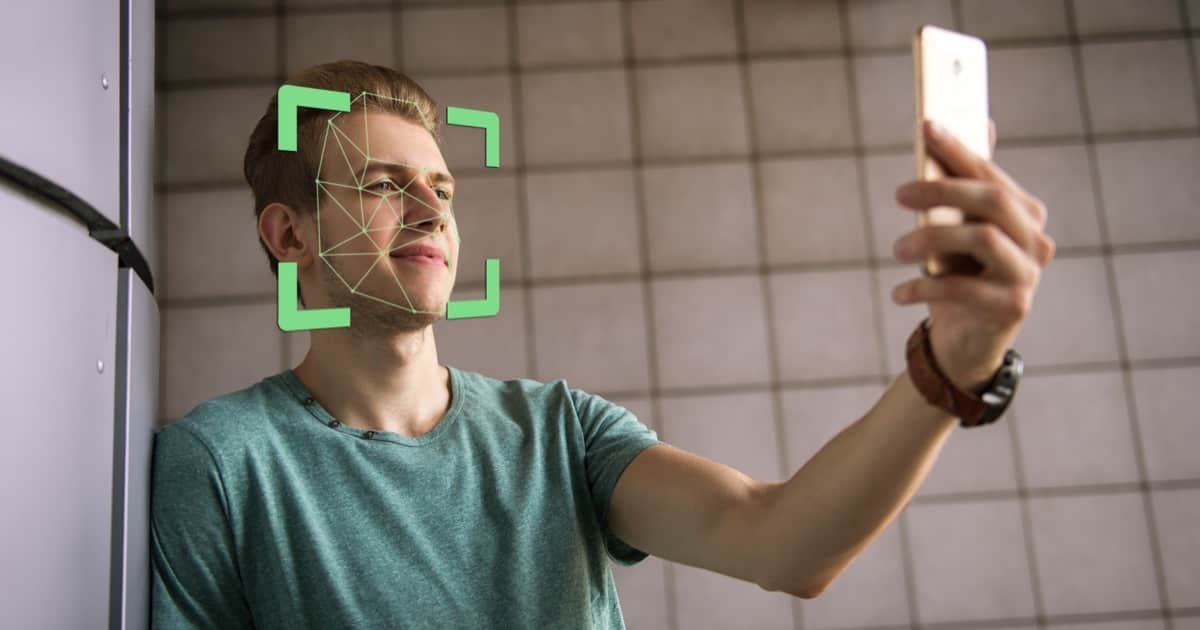 Image of man holding phone to his face to demonstrate facial recognition