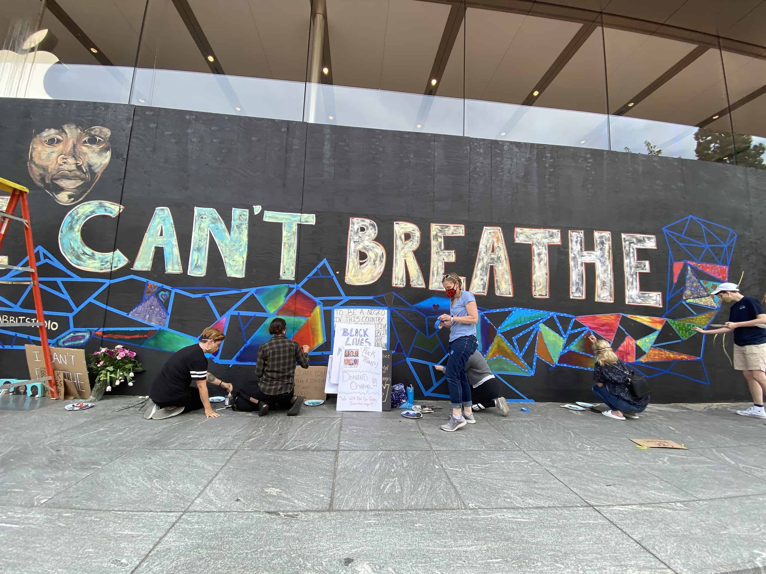 Photo of volunteers helping paint a mural on the downtown Portland Apple Store.