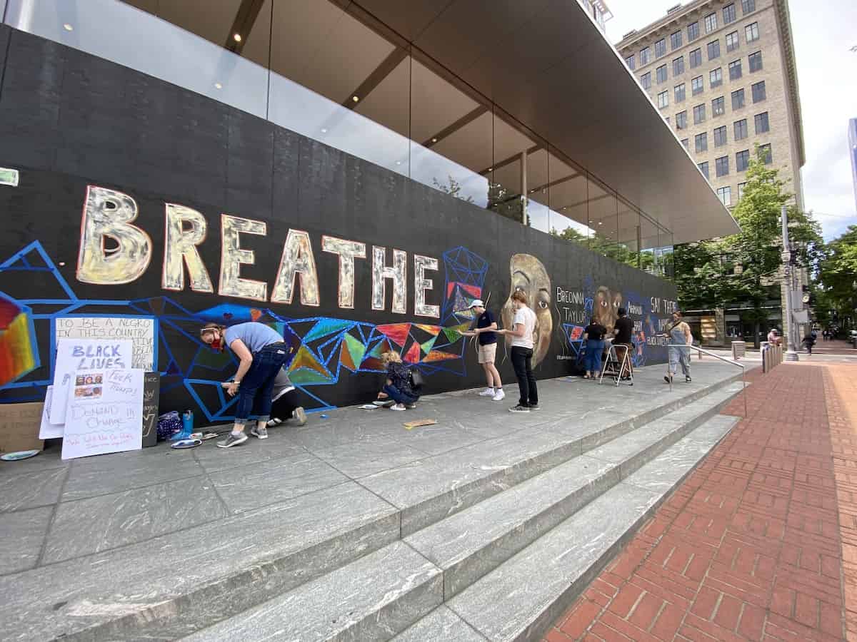 Photo of volunteers helping paint a mural on the downtown Portland Apple Store.