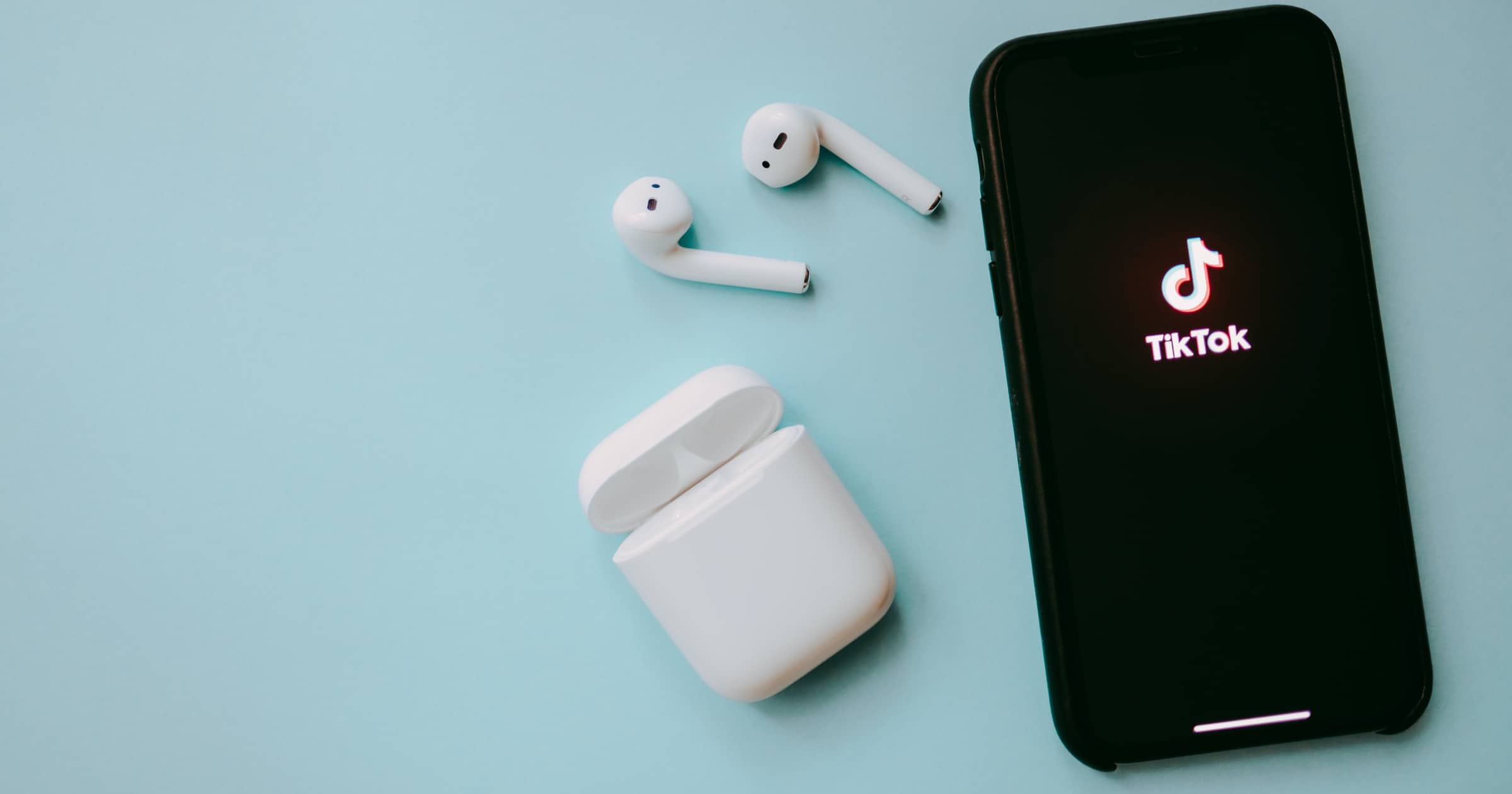 AirPods next to iPhone with TikTok logo