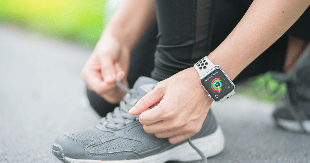 Apple Watch Fitness woman tying sport shoes laces