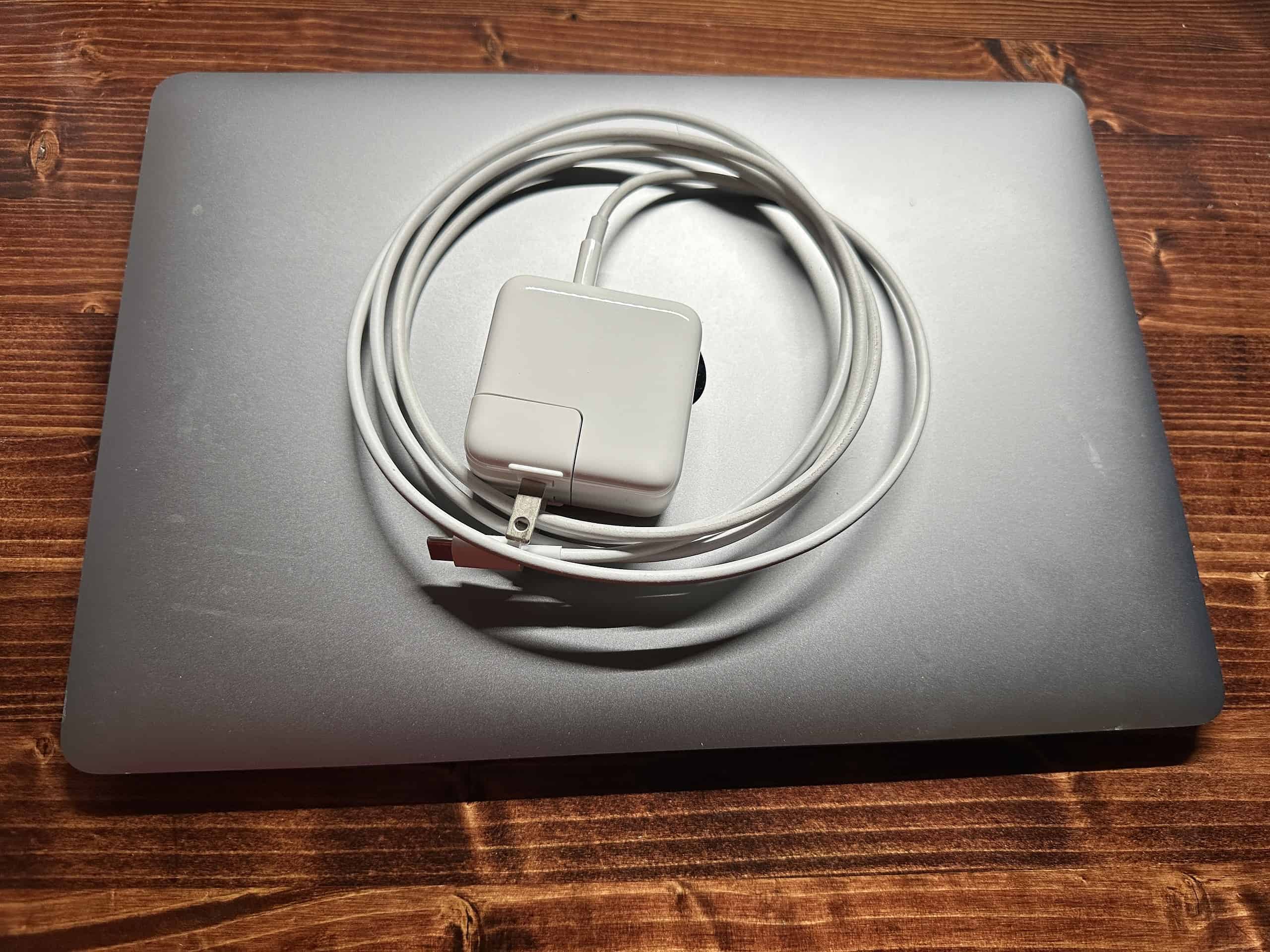 MacBook Air with a USB-C charger and adapter on top