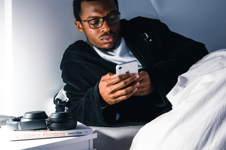 Man Using His iPhone Before Going to Sleep