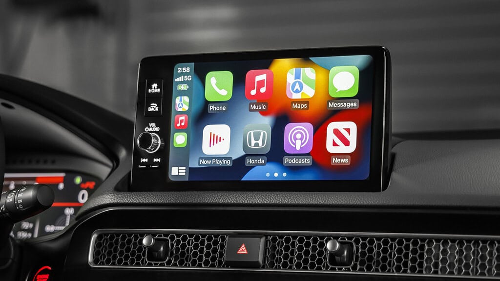 Close-up of a car dashboard touchscreen displaying Apple CarPlay apps like Phone, Music, Maps, and Messages. Time shows 2:58 PM.