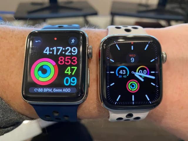 Two Apple Watches side-by-side on a wrist: the left watch (blue band) displays workout metrics including time, calories, and heart rate; the right watch (white band) shows an analog face with activity rings and the date.