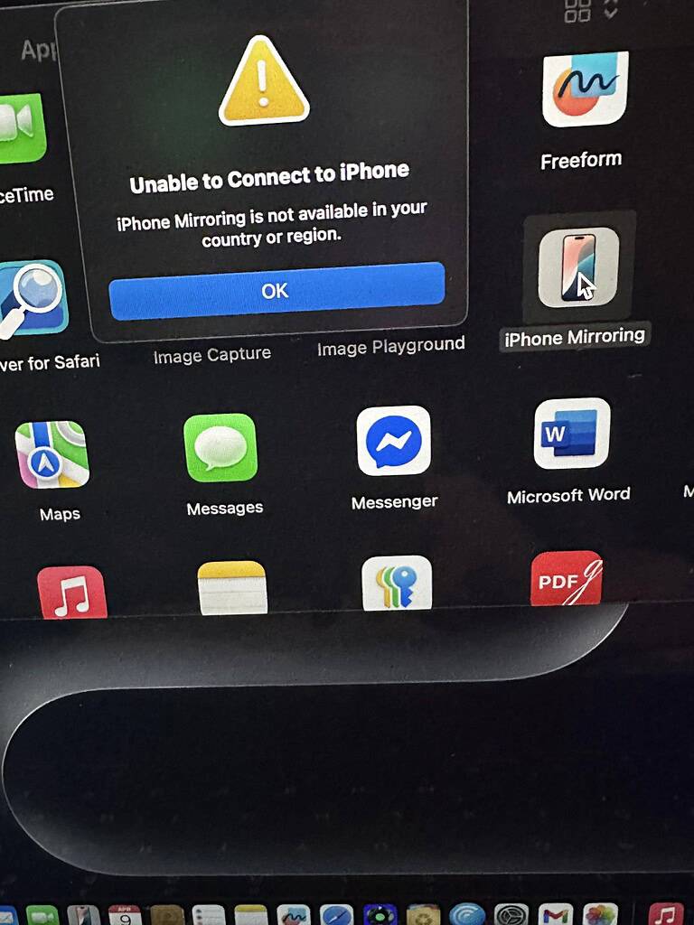 Mac-bureaublad met 'iPhone-spiegeling' app-icoon waar de cursor boven zweeft — met een foutmelding die aangeeft dat spiegeling niet beschikbaar is in jouw regio.