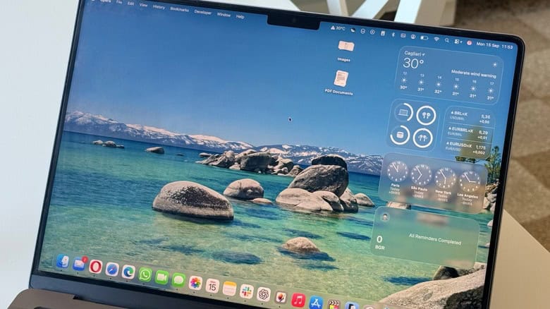 MacBook desktop with macOS Tahoe interface, featuring a scenic lake wallpaper, widgets for weather and reminders, and a dock with app icons at the bottom.