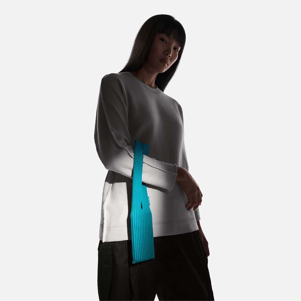 Mannequin portant la pochette iPhone d'Apple en bandoulière couleur paon