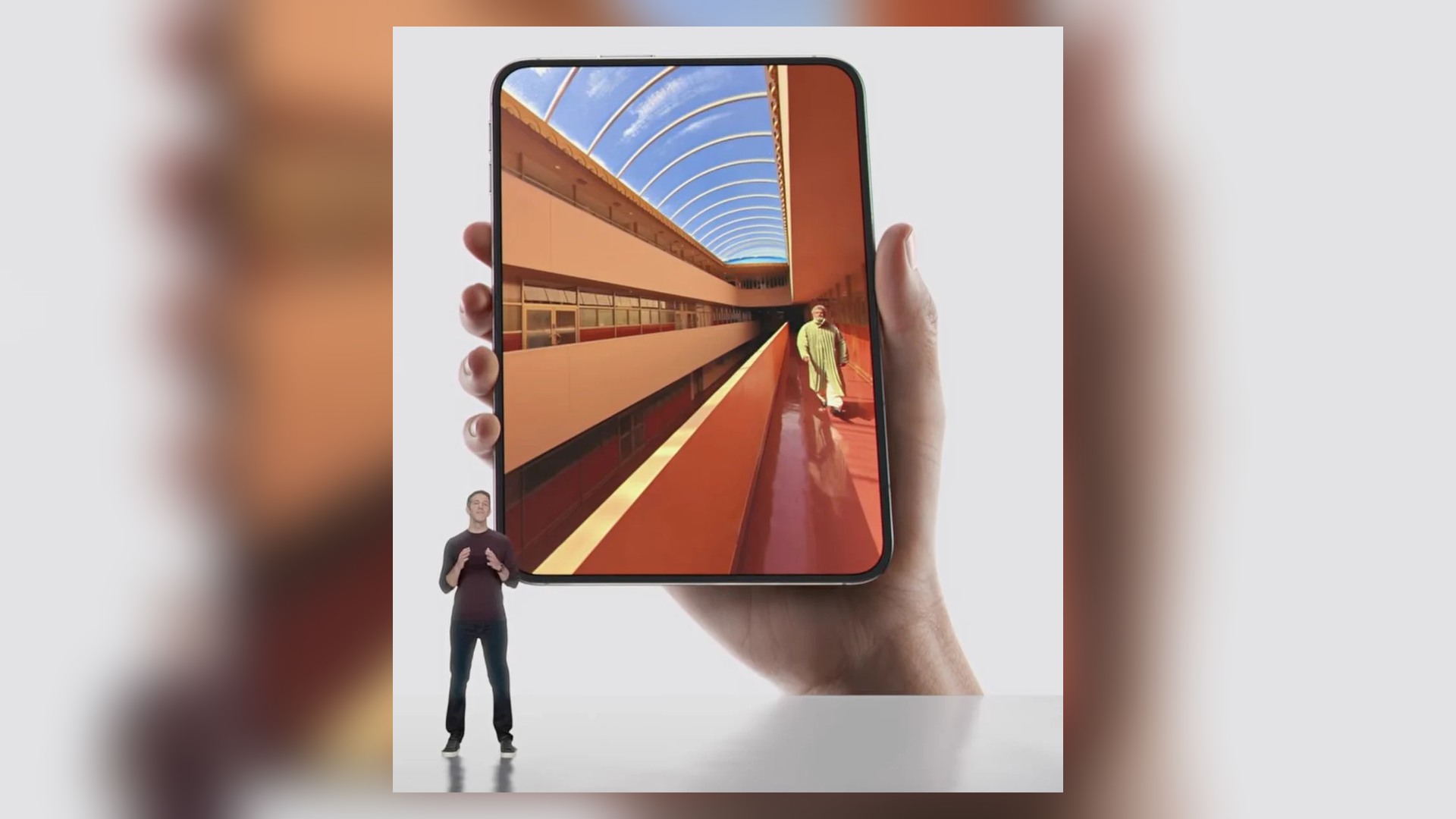 An open iPhone Duo held in one hand during an Apple presentation