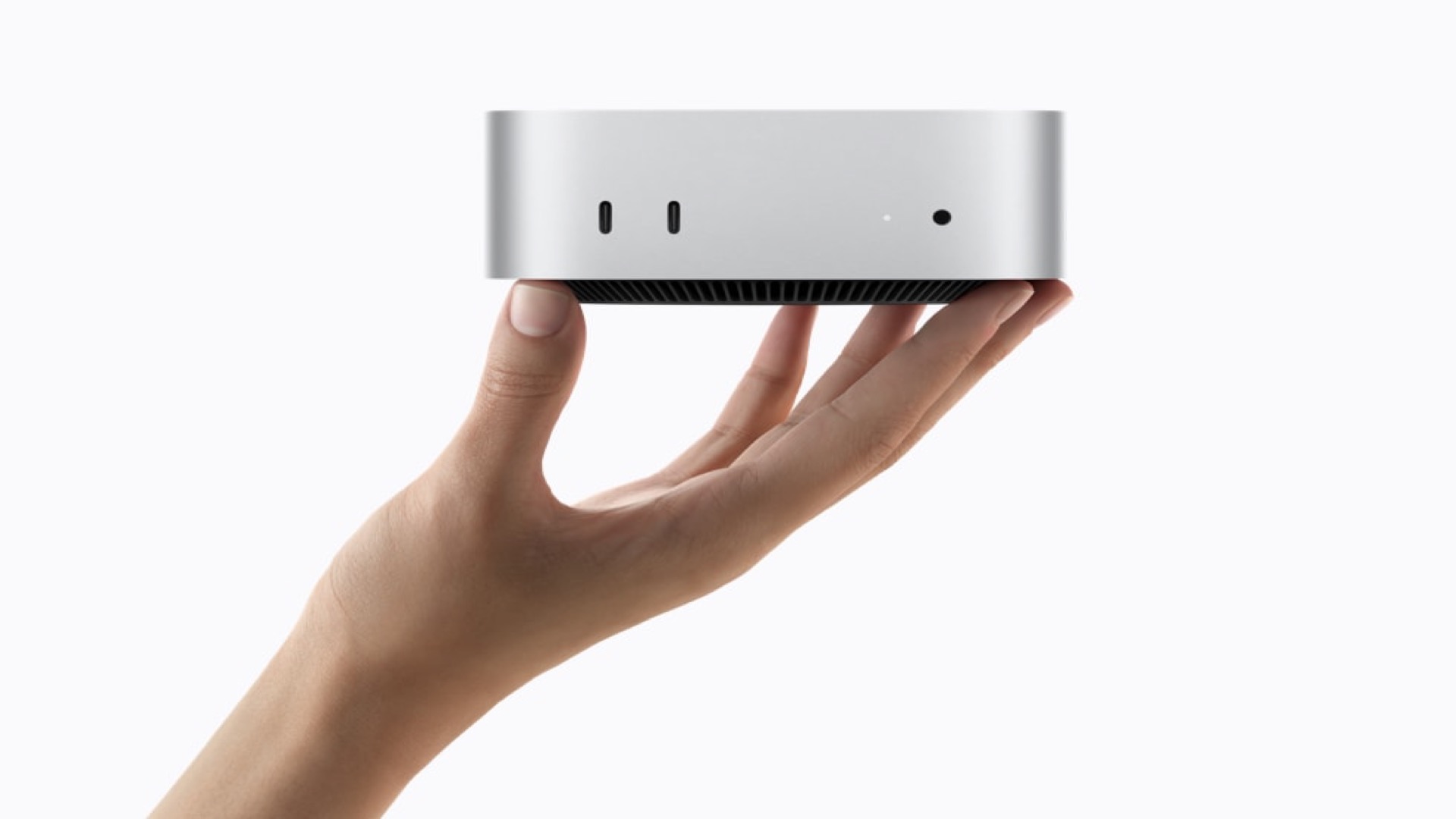 Apple Mac mini with M6 and M5 Pro held in one hand