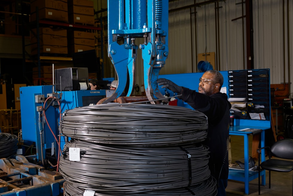 Perryman Company worker inspecting spools of titanium